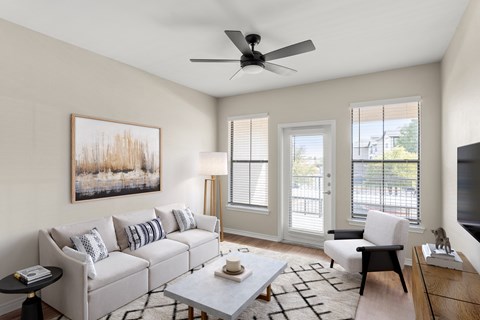 a living room with a white couch and a ceiling fan